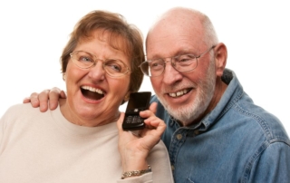 happy senior couple using cell phone isolated on a white background.
