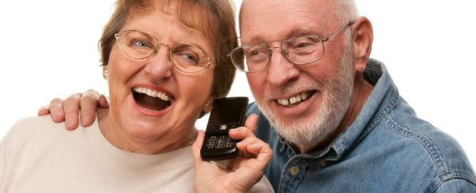 happy senior couple using cell phone isolated on a white background.