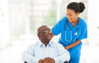 beautiful african nurse taking care of senior patient in wheelchair
