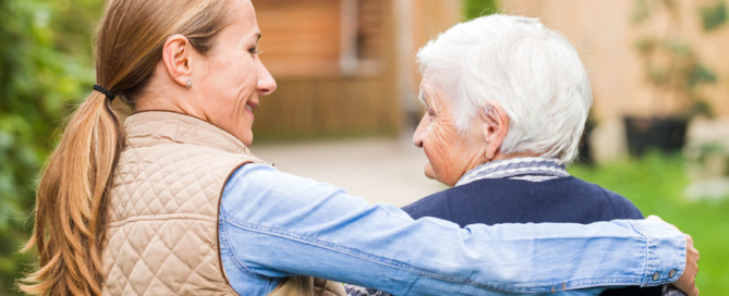 young carer walking with the elderly woman in the park