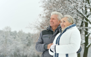 portrait of elderly couple having fun outdoors in winter forest