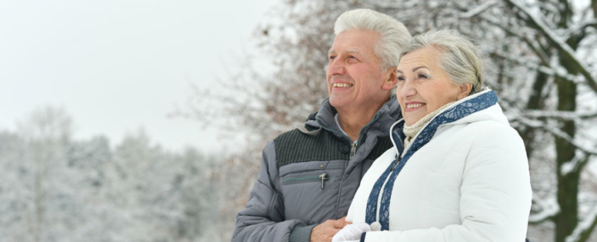portrait of elderly couple having fun outdoors in winter forest