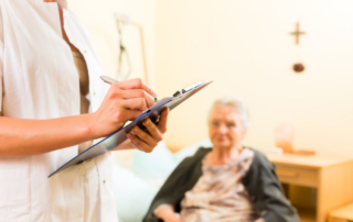 young nurse and female senior in nursing home, measurements are taken or administrative duties taken care of