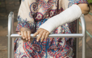 senior woman broken wrist using walker in backyard.