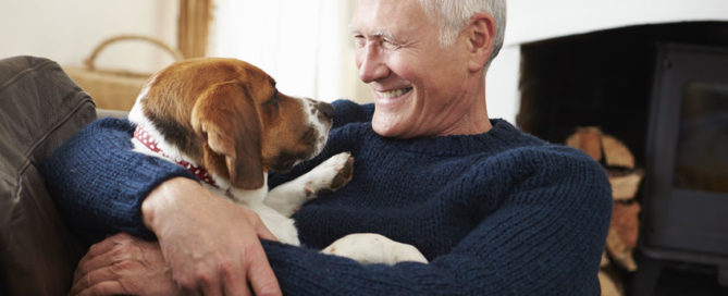 senior man relaxing at home with pet dog